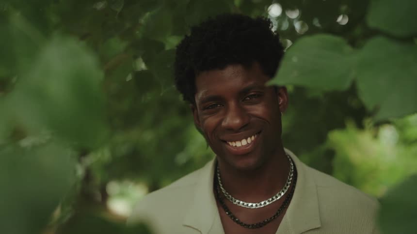 Portrait of a smiling young man amidst leaves