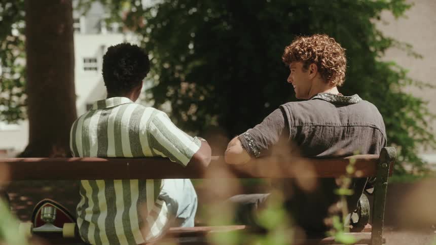Two friends talk while sitting on the bench