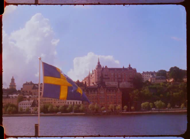 The flag blows in the wind by the shore of the city
