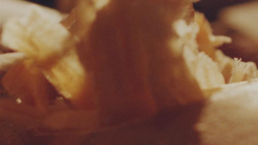 The camera is zoomed in on a pile of wood shavings