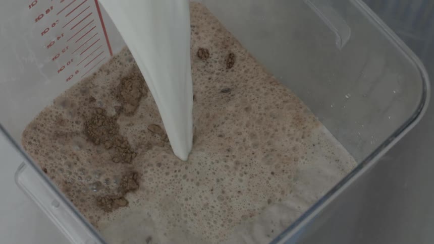 Milk is poured into a container with chocolate