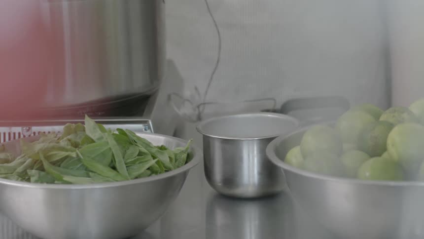 Two bowls with green foods in them sitting on a table