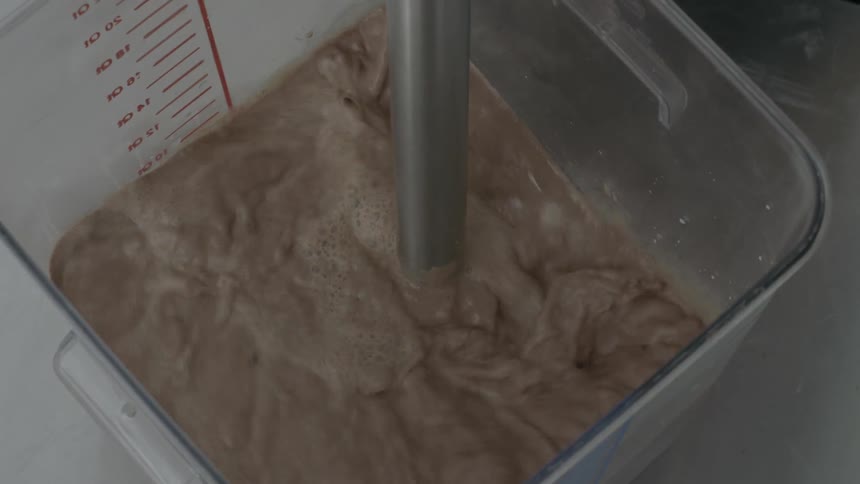 A container is being mixed with a machine