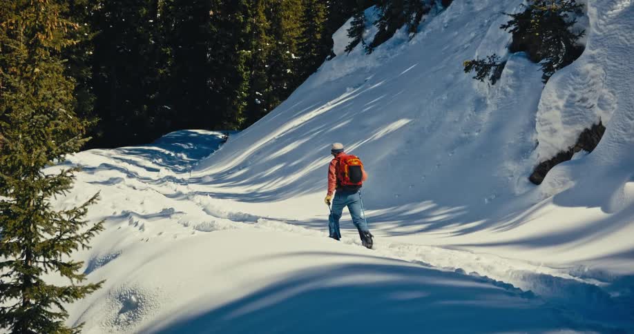 The man is hiking through the snow