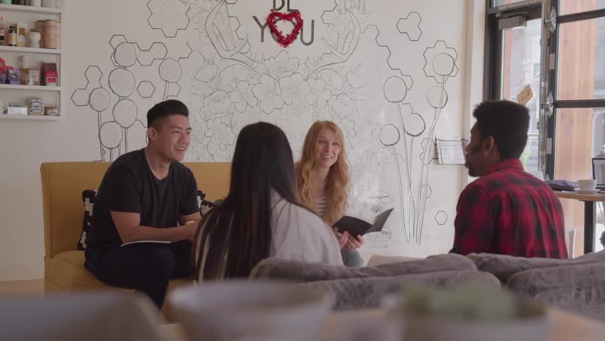 Group of four friends sitting on a couch talking