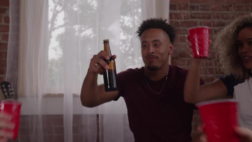 The first line shows a group of three friends at a small gathering with one friend raising a bottle to his lips the second line shows the group of friends cheering and toasting with red plastic cups and bottles