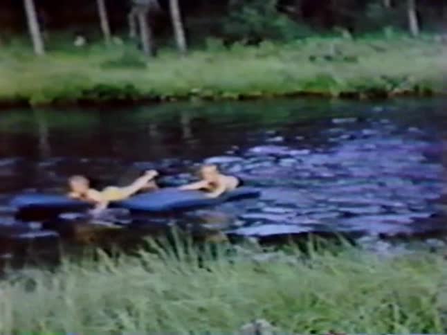 Two kids float on rafts in the water