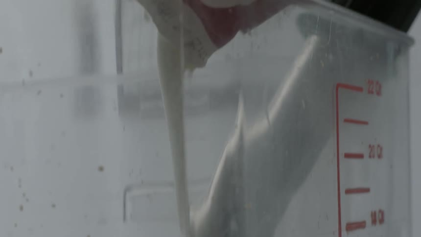 Milk is being poured into a large container