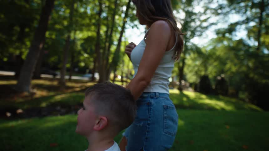 Mother and son holding hands walking in a wooded area