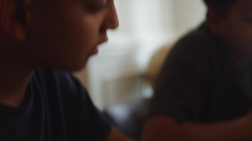 Two boys are playing a card game while sitting at a table