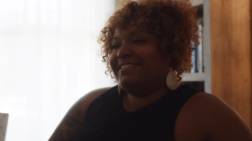 Curly haired woman sitting and talking
