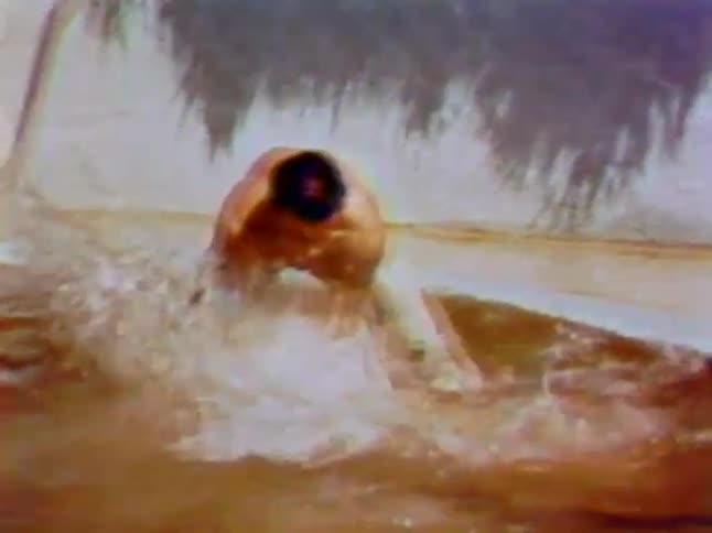 A man is grabbing an alligator in the water