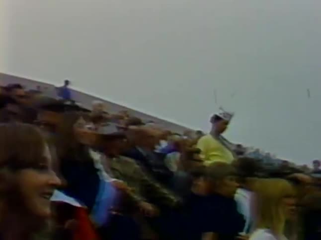 A vendor walks through a large crowd