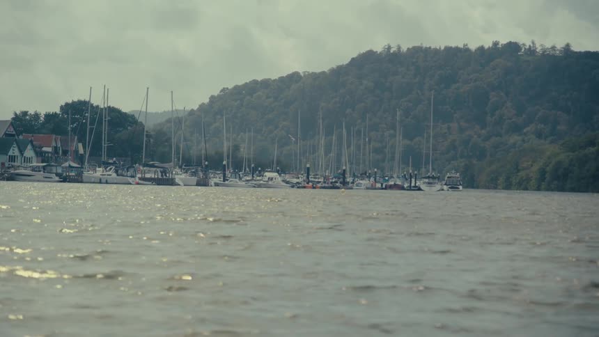 Landscape of boats and yachts at sea with mountains in the background