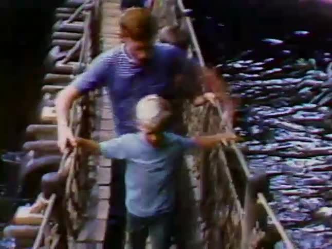 Children walk across a small bridge