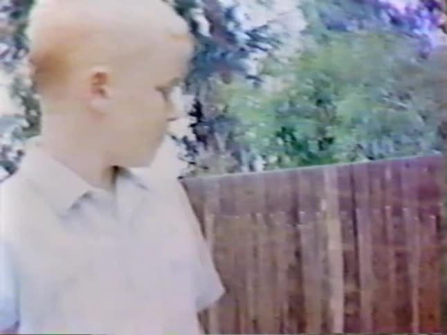 A boy walks around a yard