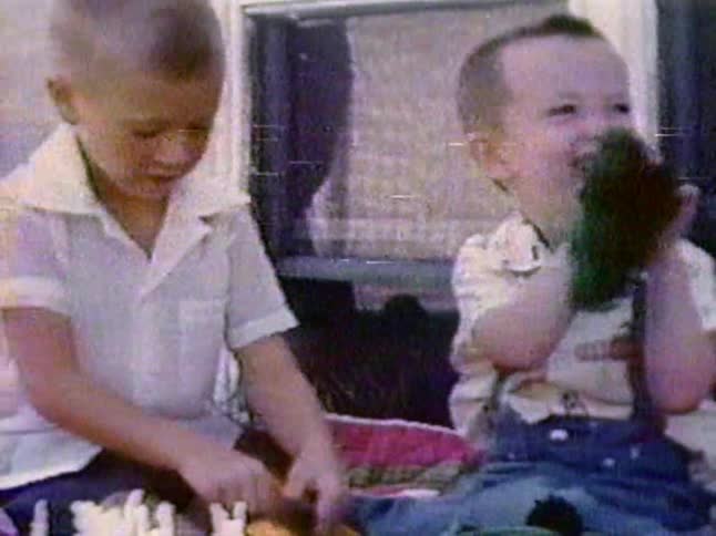 Two boys laugh while sitting outside