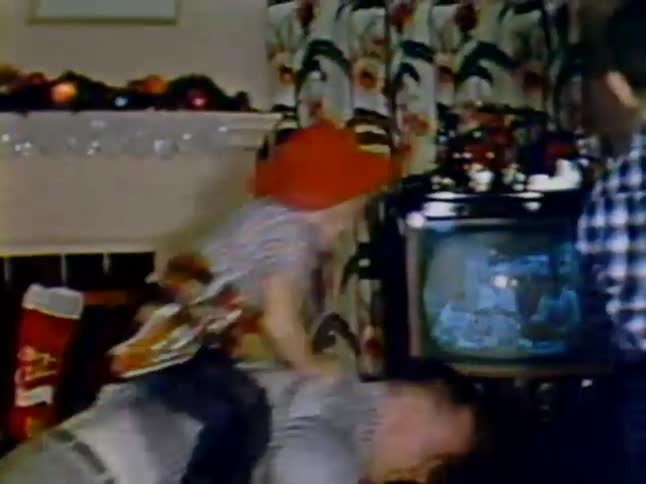 Little boy riding on man's back in living room