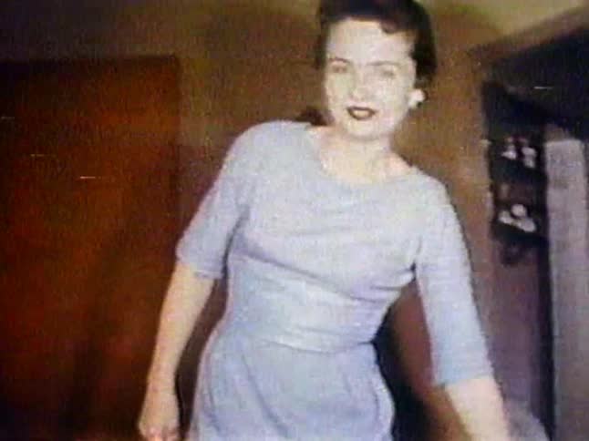A woman walks through a living room talking