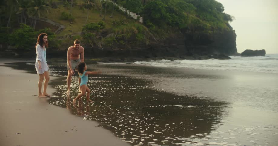 A family skip rocks on the beach