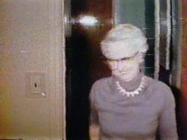 A woman enters the room smiling