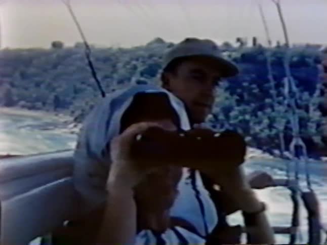 A woman picks up binoculars as a man watches on