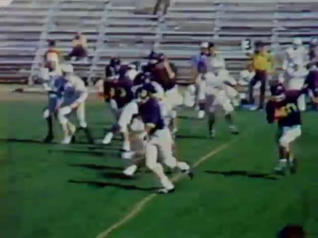 Football players charge and tackle each other