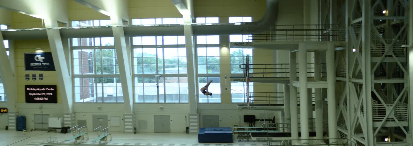 Athlete performs a somersault midair at a diving pool