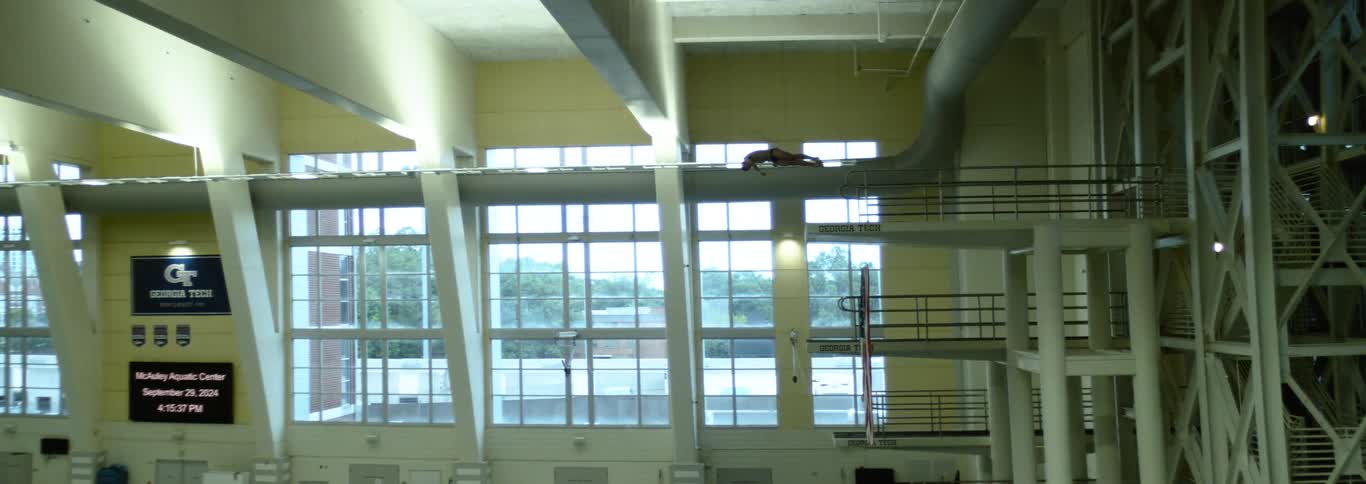 A diver starts his diving by doing an acrobatic flip off of the diving platform