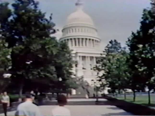 Tourists walk by the capitol building