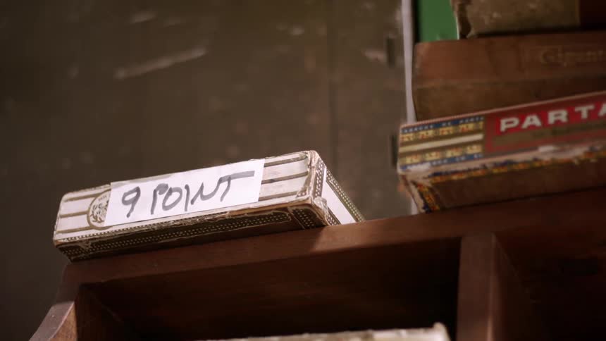 Box with a handwritten label resting on a wooden shelf