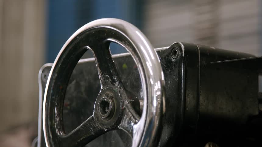 A close view shows a machines black and silver spinning wheel with a soft focus