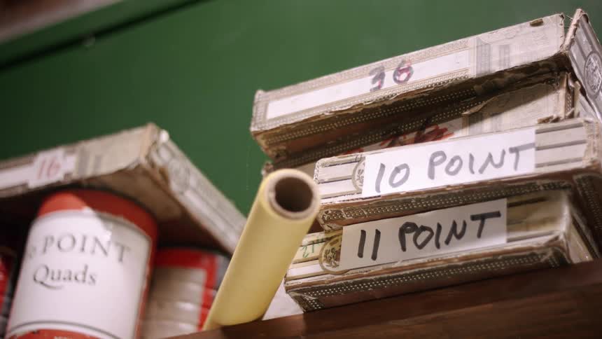 Old short boxes and a roll of paper on a tall shelf