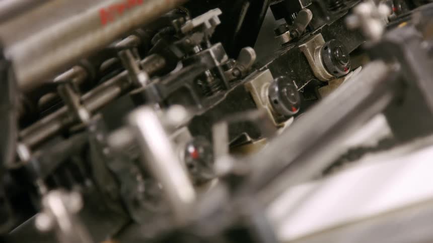 Sheets of paper move through an industrial printer in operation