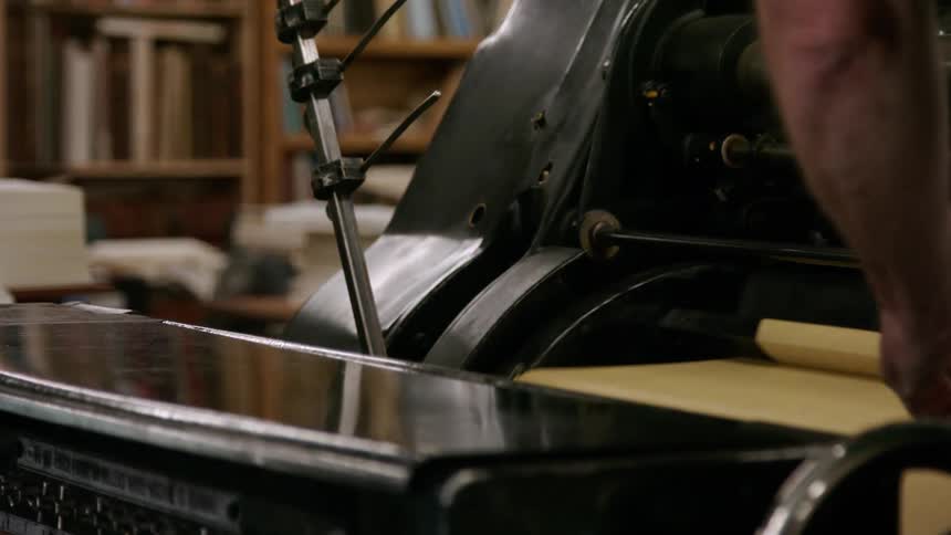 Hand rests on an old printing machine