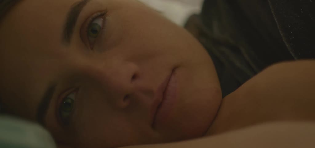 Close up of a young woman conversing while lying in bed