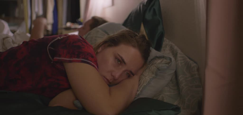 The woman lays awake as the man gets up from bed