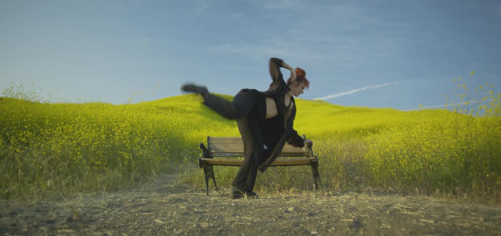 A woman dances on a bench
