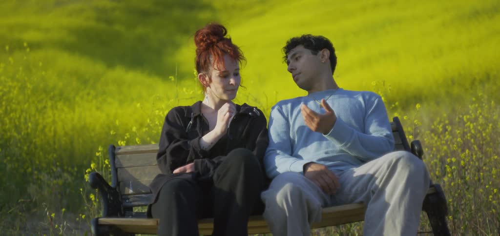 A couple hold hands on a bench