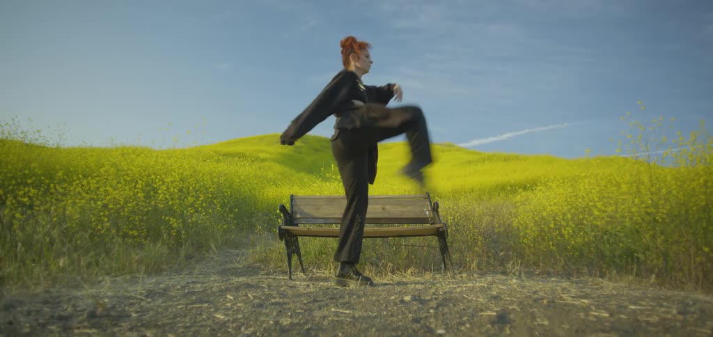 The woman is dancing by the bench