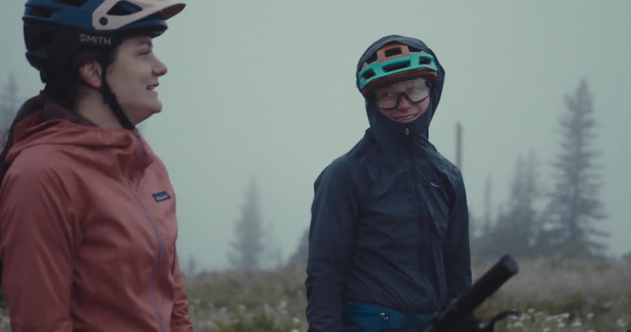 Two women talk while stopped on their bikes