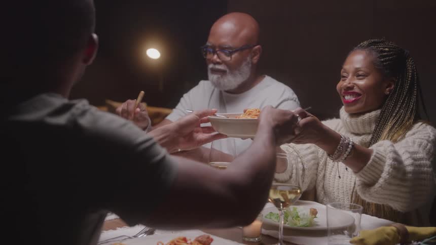 People are serving themselves dinner at the dinning table