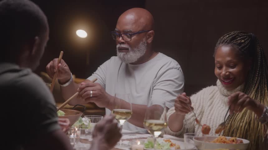 A family enjoys dinner together at a warmly lit table