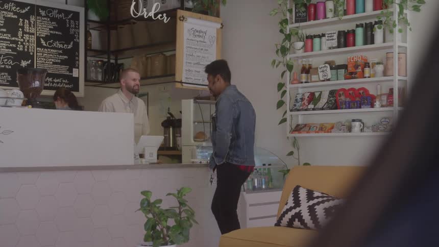 Man places an order at the counter of a modern coffee shop
