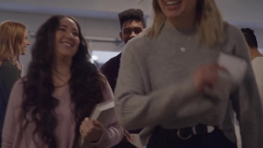 A group meets inside sharing smiles and a friendly handshake