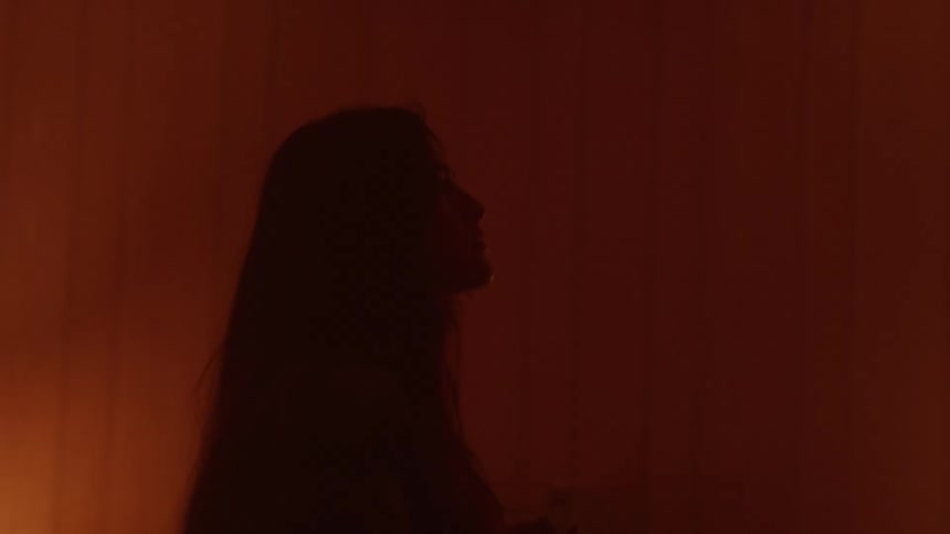 Silhouette of a woman in an environment lit by orange light