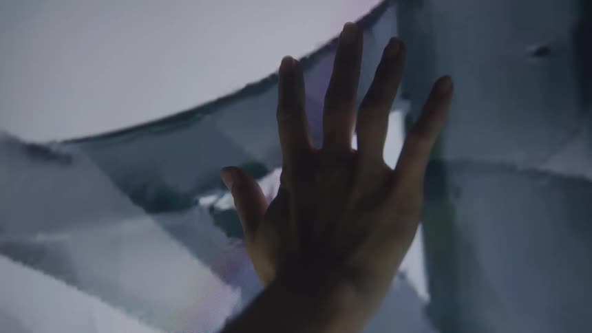 Silhouetted fingers spread against a bright panel creating a simple dreamy light study