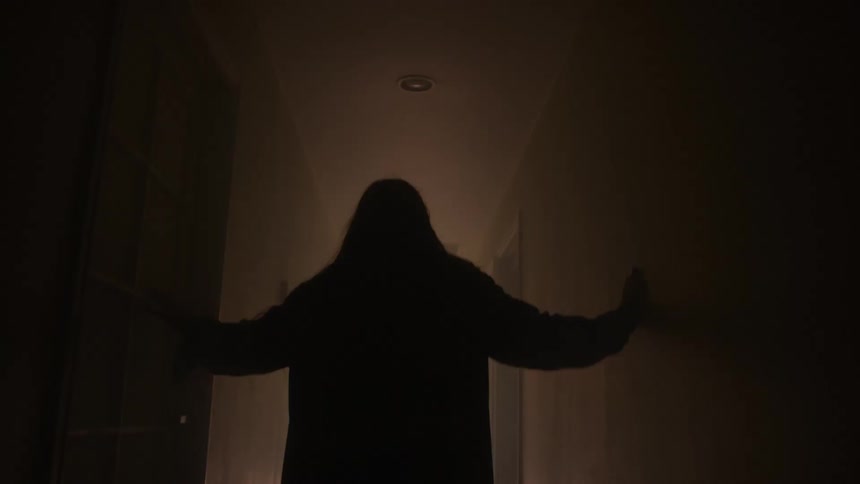 A person walking through a dark corridor in a building