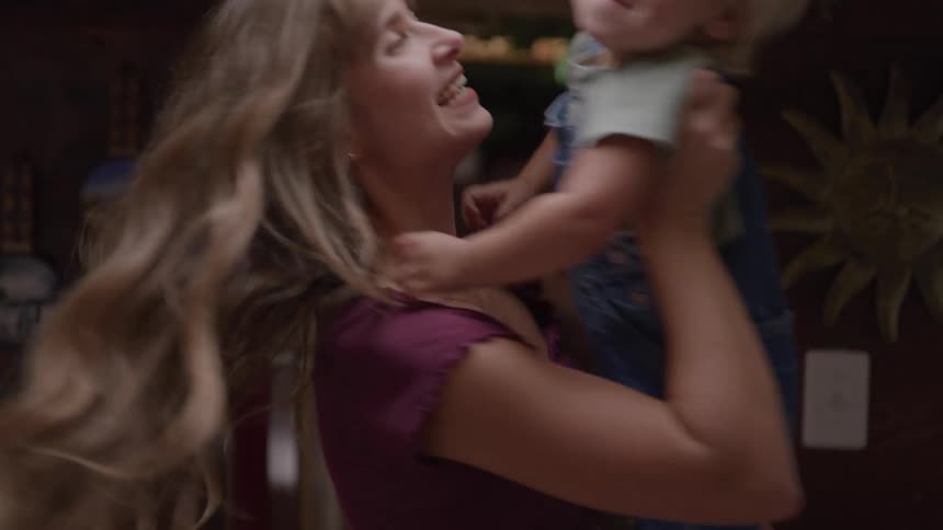 Mother plays happily with her baby son at home