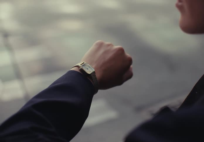 The video shows a closeup shot of a persons torso and chin but their face is not visible the person appears to be indoors in a modern setting with a blurred background